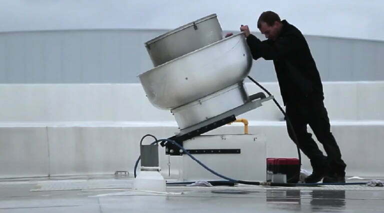 Technician closing a fan on a roof